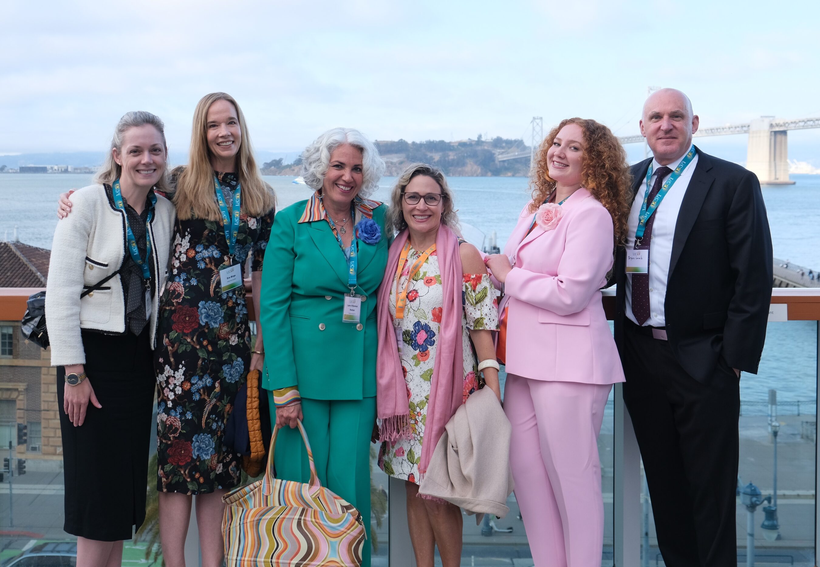A group of six people on a rooftop terrace with the Bay Bridge in the background, representing Villarreal Hutner PC, the generous donor who established our $50,000 Emerald annual event sponsorship level
